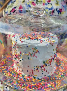 White cake covered in rainbow sprinkles